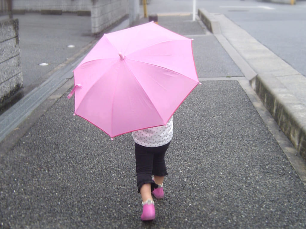 ピンクの傘をさしている少女