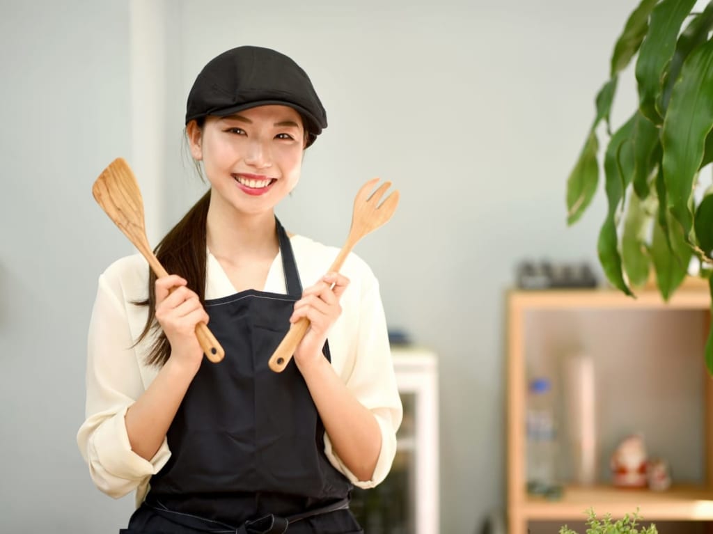 キッチン用品を手に持つ女性