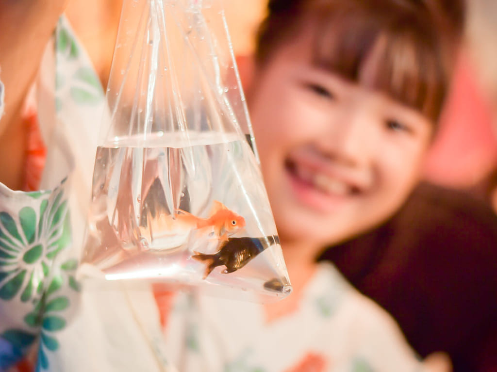 金魚すくいを楽しむ少女