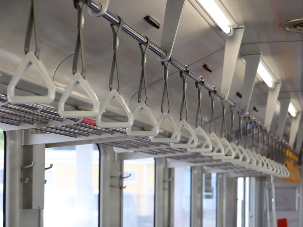 電車のつり革害散れるに並んでいる様子